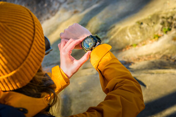 Over the shoulder view of Female Checking Current Altitudeon Casio Wrist Watch While Exploring a...