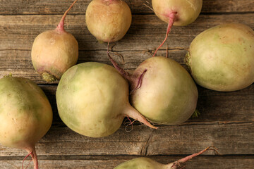 Whole fresh ripe turnips on wooden table, closeup