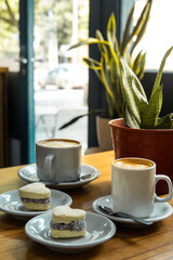 cornstarch alfajor with dulce de leche and coconut in the shape of a heart and coffee plus coffee with milk