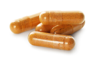 Many turmeric capsules isolated on white. Herbal dietary supplement