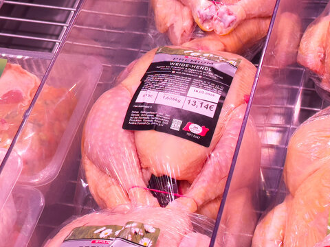 Fresh packaged whole chicken in supermarket display