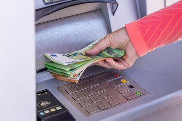 Euro money. Young woman withdraws money from ATM. Financial concept. Cash payments