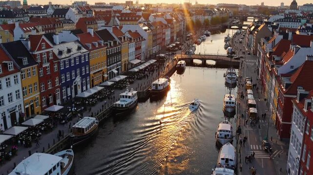 Backlight sunset footage from Copenhagen, Denmark. bridge in Nyhavn New Harbour canal and entertainment district. Aerial Video footage view from the top. forward movement. Sunset golden time light 