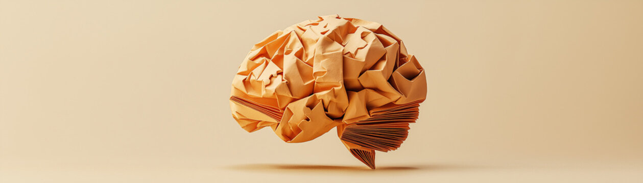 Origami brain made of folded paper, against a minimalist beige background