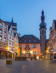 Naklejka premium Evening view of the historic Market Square in Cochem, Germany, with half-timbered houses, town hall and tower of St. Martin's Church