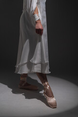 legs of a ballerina in a white dress