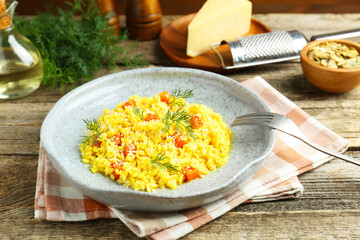 Delicious pumpkin risotto served on wooden table, closeup