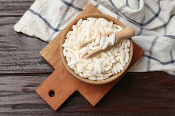 Puffed rice in bowl and scoop on wooden table, top view