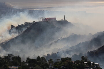 Fototapeta premium Palisades Wildfire Raging Through California’s Coastal Landscape – Thick Smoke and Scorched Terrain in Los Angeles Wildfire Disaste