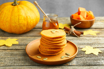 Tasty pumpkin pancakes with seeds served on wooden table