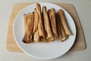 Crunchy golden tacos prepared on a white plate: ready to be served