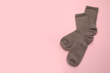 Pair of soft socks on pink background, top view. Space for text