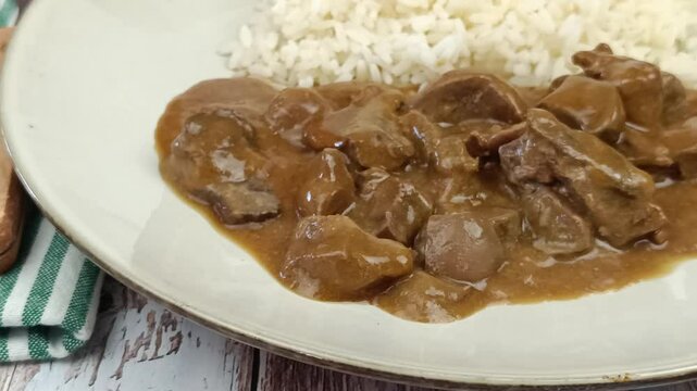 rognons de boeuf en sauce et riz dans une assiette