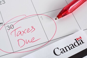 Closeup calendar with circled April 30 date with words Taxes Due to Canada Revenue Agency