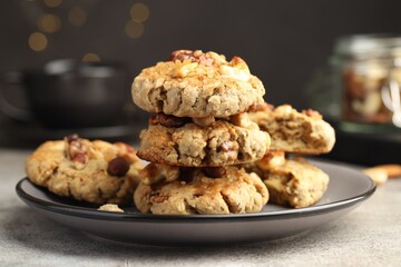 Tasty cookies with nuts on gray textured table, closeup