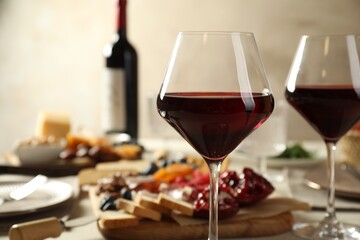 Red wine and different snacks served on table, closeup. Space for text