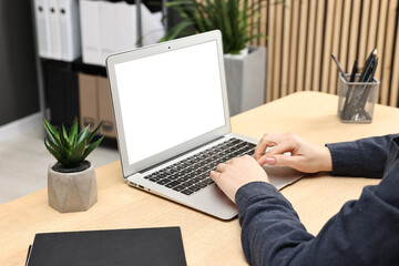 Woman working on computer at desk indoors, closeup