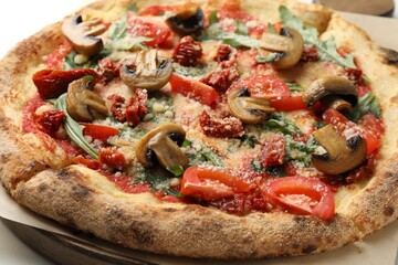 Tasty pizza with mushrooms, tomatoes and arugula on table, closeup