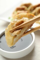 Eating fried gyoza dumplings at white table, closeup
