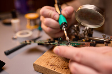 Hands Carefully Repairing a Circuit Board with a Soldering Tool for Electronics Projects