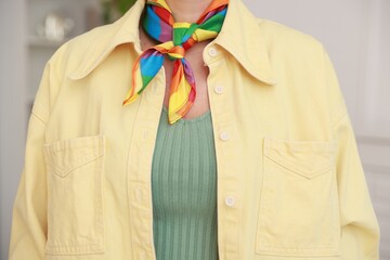 Woman wearing neckerchief in LGBT colors indoors, closeup