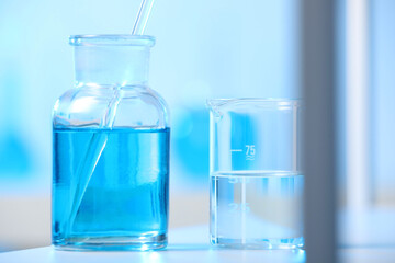 Laboratory glassware with liquid on shelf indoors, closeup