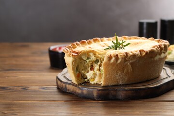 Delicious fresh homemade pie with rosemary on wooden table, space for text