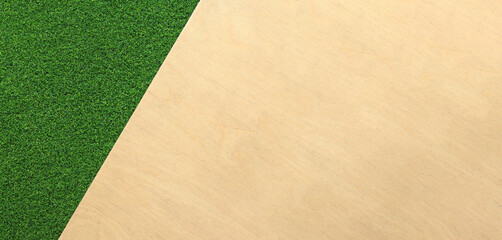 Green artificial grass rug on a wooden background. Artificial grass, top view. Background