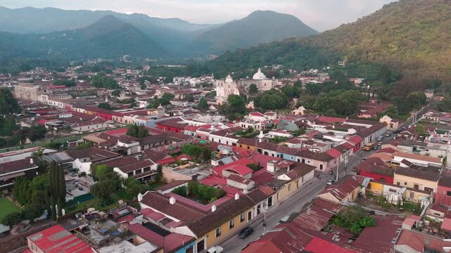 Paisaje urbano de pueblo colonial con casas de techos rojos rodeado de monta&ntilde;a, Antigua Guatemala, Guatemala