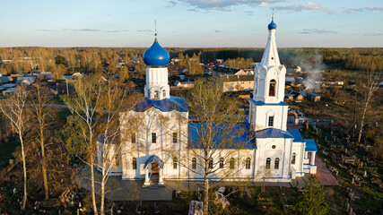 Large white church with blue domes and a blue roof. A beautiful stone church in a rural cemetery