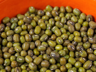 Mung beans on a light background, emphasizing their shape and texture, create a feeling of freshness and naturalness.