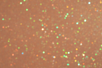 Abstract orange and gold glitter texture with shimmering colorful bokeh lights