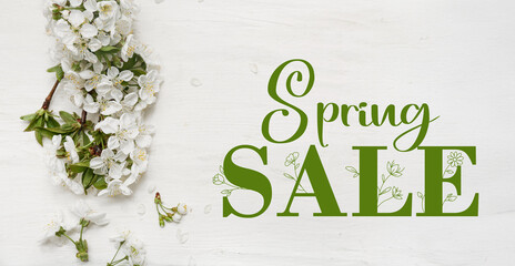 Beautiful blossoming branch and petals on white wooden background