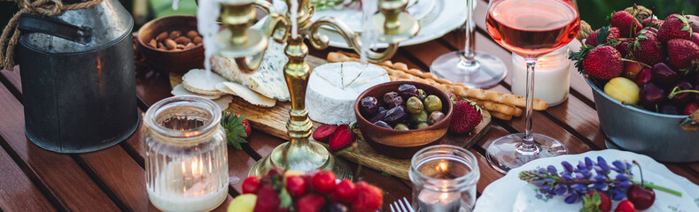 Banner. Perfect surprise date for loving couple, private wedding, romantic marriage proposal. Summer, sunset, golden hour. Beautiful elegant outdoor arrangement in meadow with purple blue lupins