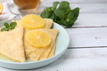 Delicious Crepes Suzette on white wooden table, closeup. Space for text