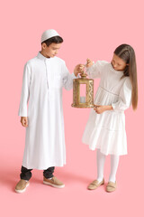Little Muslim children with fanous lantern on pink background