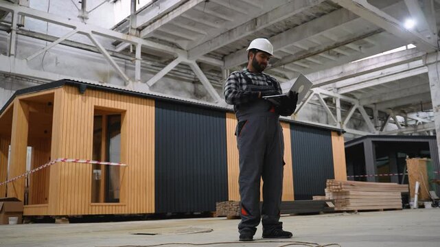 Indian engineer reviewing prefab house construction plans