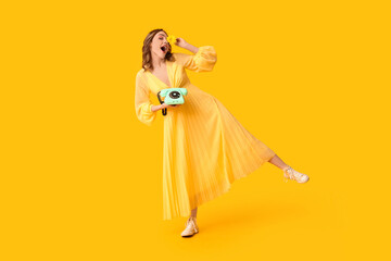 Young woman with retro telephone and beautiful chrysanthemum flower on yellow background. International Women's Day