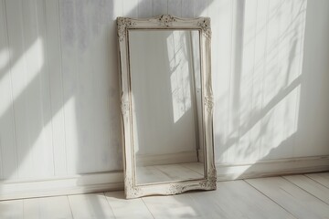 Fototapeta premium A mirror with a white frame leaning against a white wall with sunlight shining in