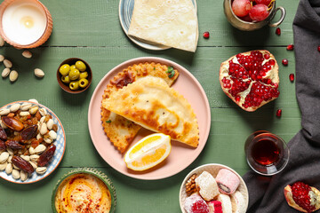 Traditional Eastern dishes and Turkish tea on green wooden table. Ramadan celebration