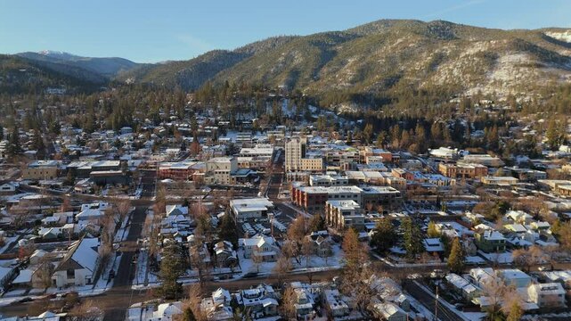 Winter Aerial Ascent Over Snow-Covered Mountain Town Ashland, Oregon at Sunrise