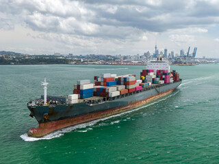 Container ship  sails past Auckland skyline. International cargo transport. Waitemata Harbour,...
