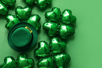 Balloons in shape of clover and leprechaun's hat on green background. St. Patrick's Day celebration