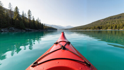Fototapeta premium Red kayak gliding across a turquoise lake surrounded by mountains and pine trees