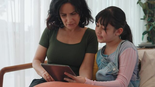 Granddaughter guide grandmother how to use touch screen control tablet. Senior adapt to technology activity communicate new generation kid cross generation gap strengthen family bond. Divergence.