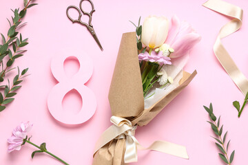 Mini bouquet of beautiful spring flowers in wrapping paper with eucalyptus, scissors and figure 8 on pink background. International Women's Day