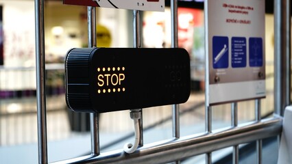 Electronic stop sign at shopping mall entrance, illuminated display indicating restricted access in...