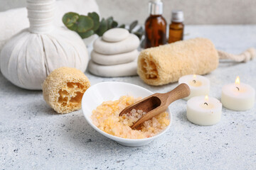 Beautiful composition with loofah, herbal bag, sea salt, scoop and candles on grunge background, closeup