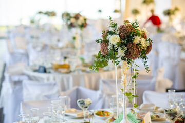 Beautifully decorated wedding table with a floral centerpiece and elegant place settings for a formal event.