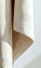 Natural linen fabric with gentle folds and texture creates soft shadows against white background, showcasing organic textile draping for interior design use.